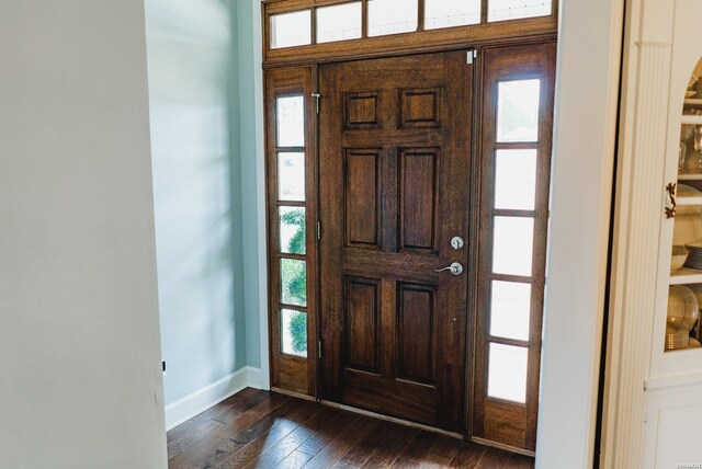 entrance foyer with dark wood-style flooring and baseboards