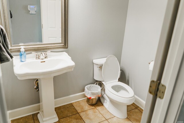 bathroom featuring toilet, tile patterned flooring, and baseboards