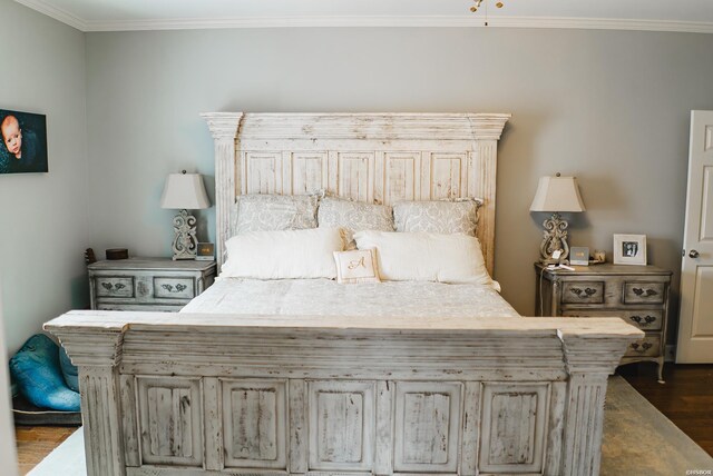 bedroom featuring ornamental molding and dark wood finished floors