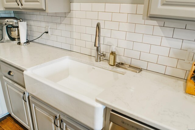 kitchen featuring dark wood-style floors, tasteful backsplash, a sink, and gray cabinetry