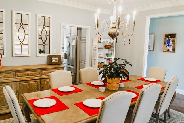 dining area featuring ornamental molding, a notable chandelier, and dark wood-style floors