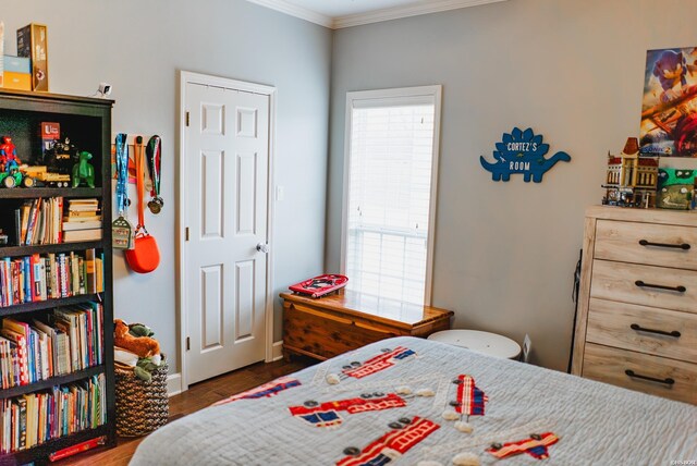 bedroom with dark wood finished floors and crown molding