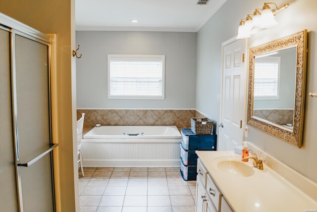 full bath with a garden tub, vanity, a wealth of natural light, and tile patterned floors