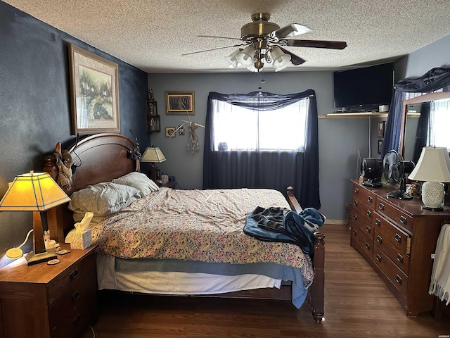 bedroom featuring dark wood-style floors, a textured ceiling, and a ceiling fan