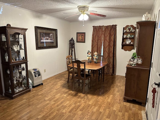 dining room with light wood-type flooring, ceiling fan, a textured ceiling, and heating unit