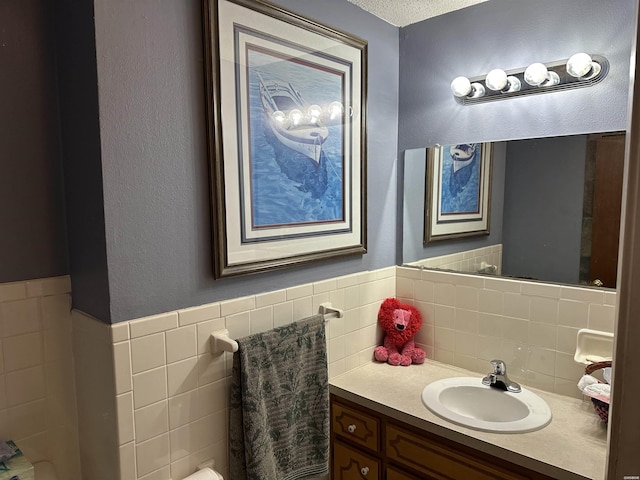 bathroom featuring tile walls, a wainscoted wall, and vanity