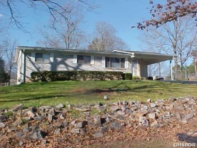 view of front of house featuring an attached carport and a front yard