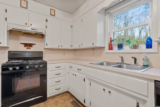 kitchen with black gas range, light countertops, under cabinet range hood, white cabinetry, and a sink