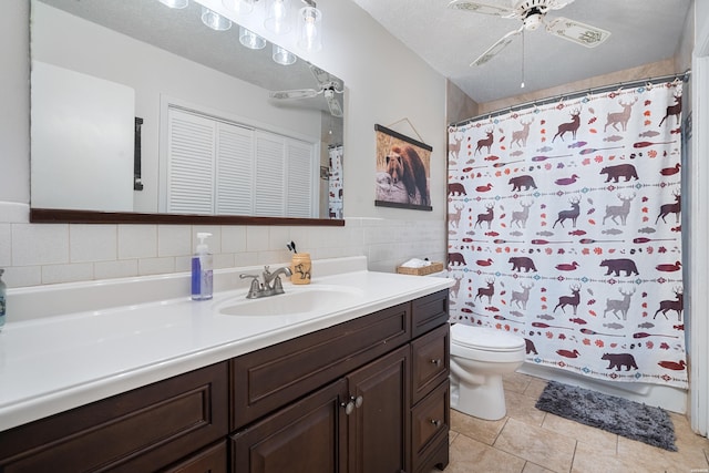 full bath with tile walls, toilet, a textured ceiling, vanity, and tile patterned flooring