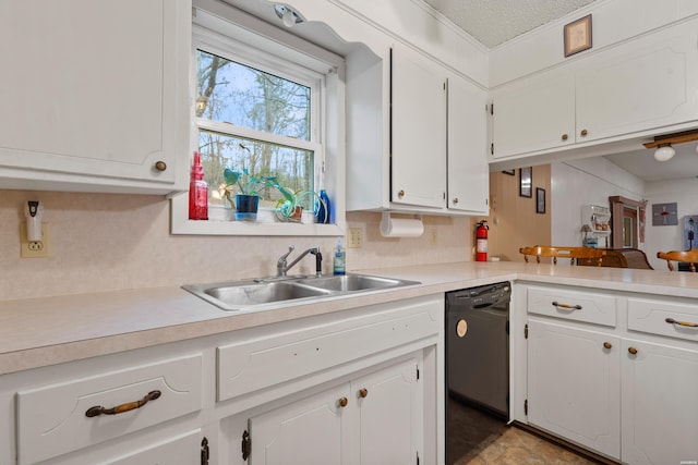 kitchen with a peninsula, a sink, white cabinetry, light countertops, and dishwasher