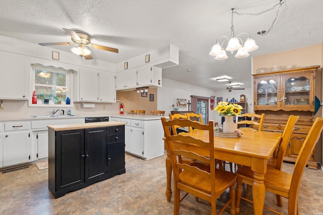 kitchen with white cabinetry, light countertops, dark cabinetry, a center island, and decorative light fixtures