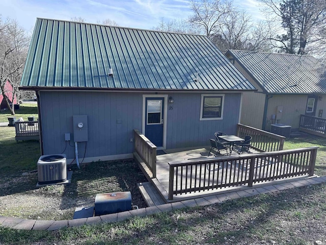 back of property featuring outdoor dining space, metal roof, central AC, and a wooden deck