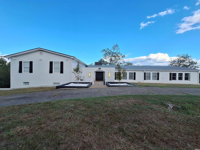 back of property with crawl space and a lawn