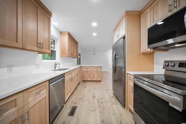 101 Southern Hills Dr, Hot Springs, AR 71913 - kitchen with appliances with stainless steel finishes, light brown cabinetry, a sink, light wood-style flooring, and a peninsula