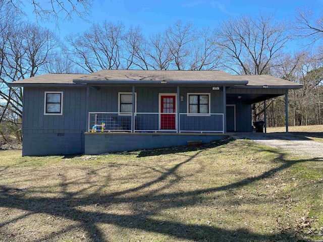 view of front of property featuring dirt driveway, crawl space, covered porch, a carport, and a front yard