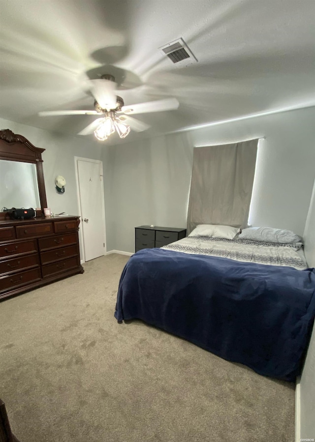 bedroom with light colored carpet, visible vents, and ceiling fan