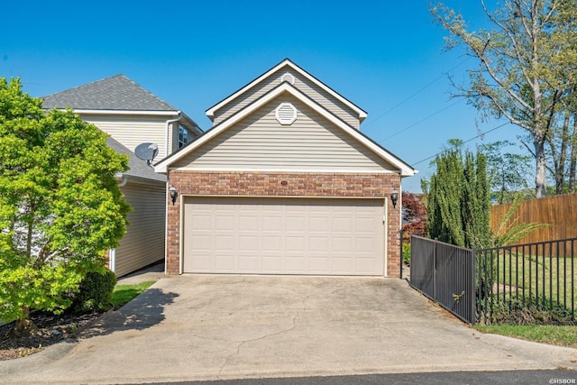 garage featuring driveway and fence
