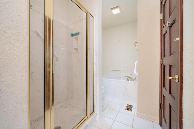 bathroom featuring a stall shower, a garden tub, and tile patterned floors