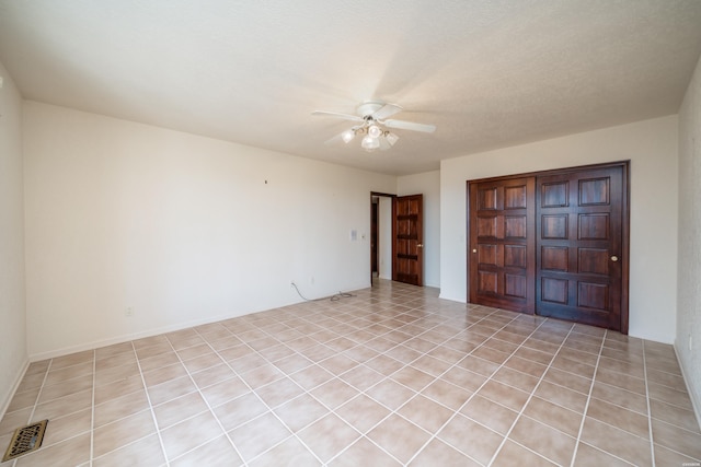 interior space featuring light tile patterned floors, a closet, visible vents, and a ceiling fan