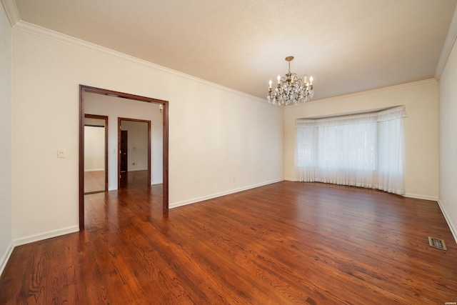 unfurnished room featuring baseboards, visible vents, dark wood-style floors, an inviting chandelier, and crown molding