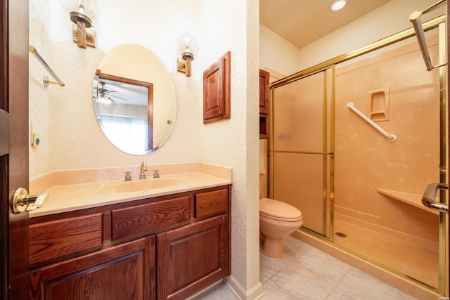 bathroom featuring a stall shower, a textured wall, toilet, tile patterned flooring, and vanity