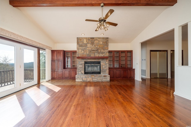 unfurnished living room featuring beam ceiling, a fireplace, a ceiling fan, wood finished floors, and high vaulted ceiling