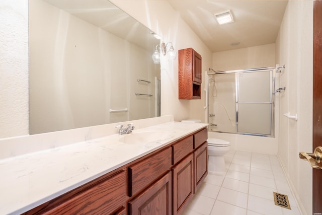 bathroom with visible vents, toilet, enclosed tub / shower combo, vanity, and tile patterned flooring