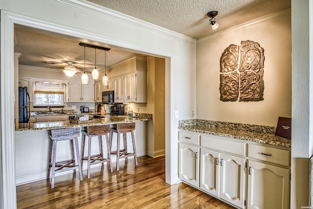 208 Daffodil St Unit D-1, Hot Springs, AR 71913 - kitchen featuring white cabinets, ornamental molding, decorative light fixtures, light wood-type flooring, and black microwave