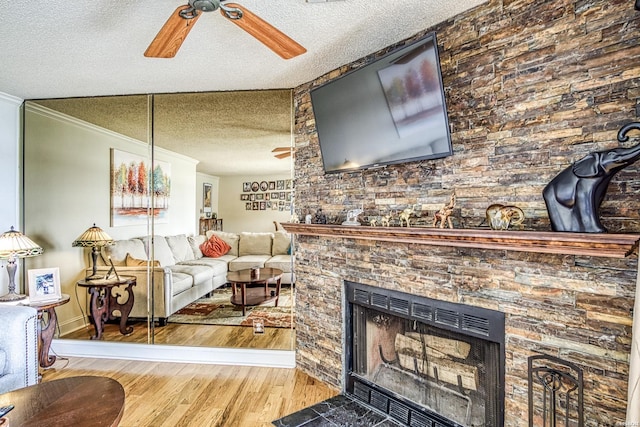 208 Daffodil St Unit D-1, Hot Springs, AR 71913 - living area with crown molding, light wood-style flooring, a large fireplace, ceiling fan, and a textured ceiling
