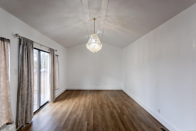 spare room with lofted ceiling, wood finished floors, visible vents, and baseboards