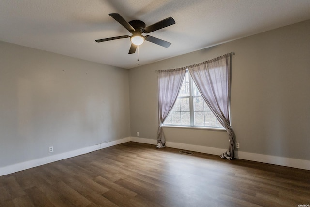 unfurnished room featuring ceiling fan, a textured ceiling, wood finished floors, visible vents, and baseboards