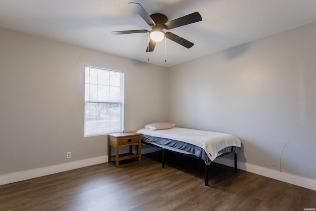 bedroom featuring a ceiling fan, baseboards, and dark wood-style flooring