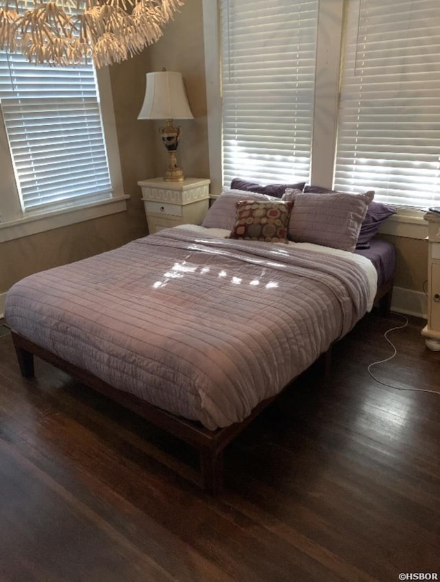 bedroom featuring multiple windows and dark wood-style flooring