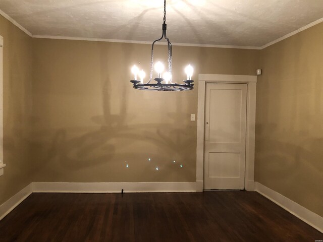 unfurnished dining area with dark wood-style floors, crown molding, and baseboards