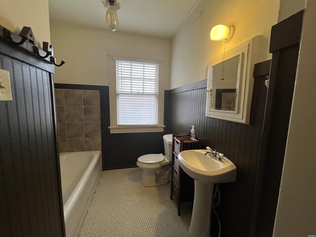 bathroom with toilet, a washtub, and a sink