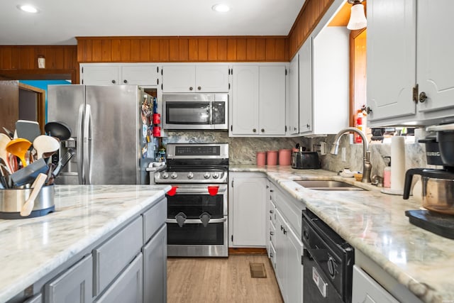 kitchen with stainless steel appliances, a sink, and white cabinets