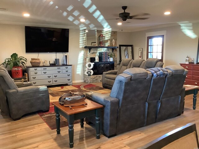 living room featuring a fireplace, recessed lighting, visible vents, light wood-style flooring, and a ceiling fan