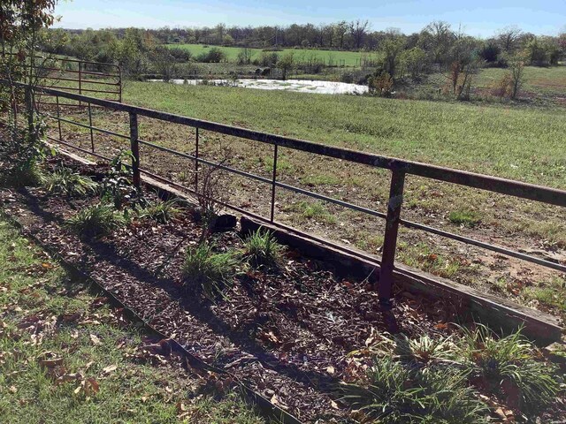 view of yard with fence and a rural view