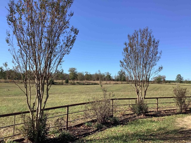 view of yard with a rural view and fence