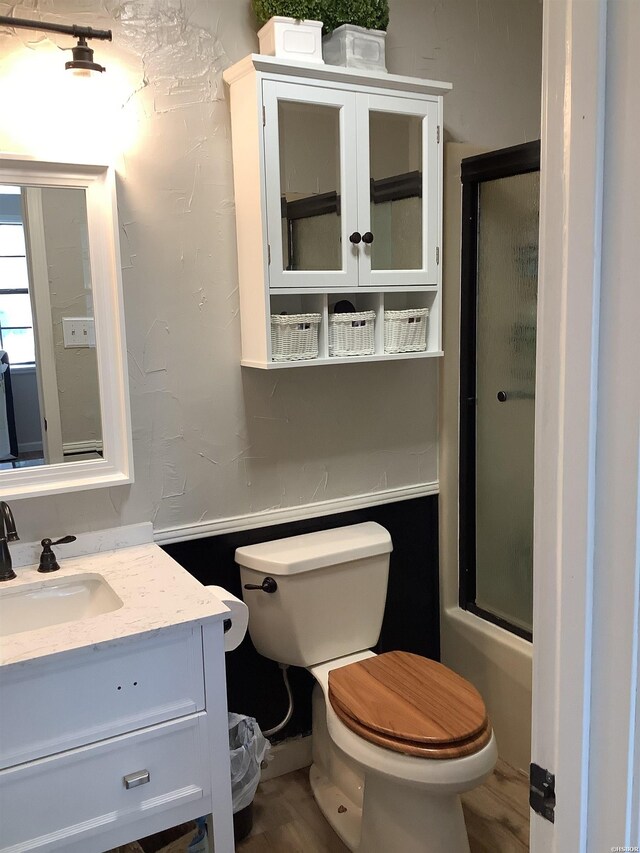 full bathroom featuring toilet, enclosed tub / shower combo, and vanity