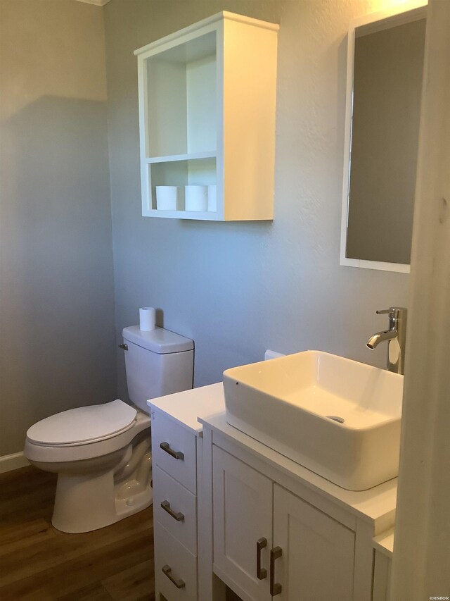 bathroom featuring toilet, wood finished floors, and vanity