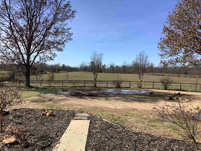 view of yard featuring a rural view and fence