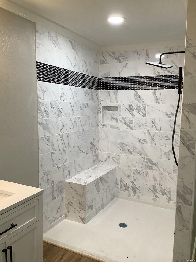 bathroom featuring tiled shower and vanity