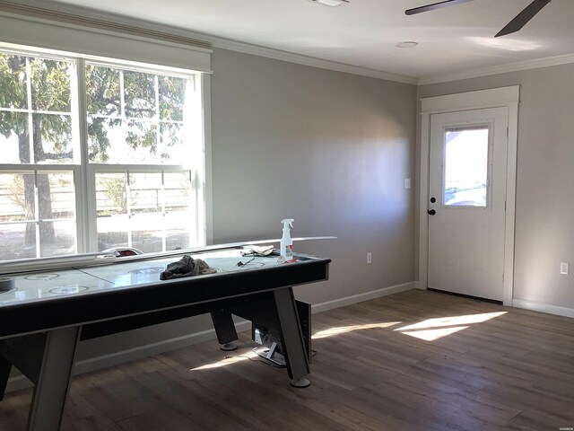 rec room with dark wood-style floors, baseboards, and crown molding