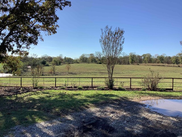 view of yard with a rural view and fence