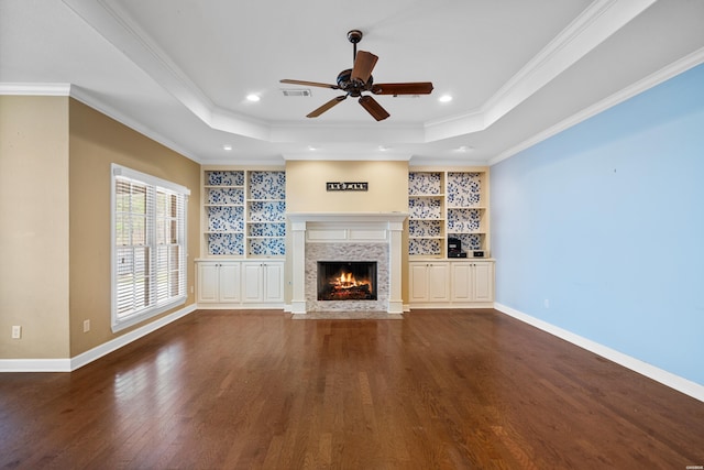 121 Gardens Gate Dr, Hot Springs, AR 71913 - unfurnished living room with ornamental molding, dark wood finished floors, ceiling fan, a tray ceiling, and a fireplace with flush hearth