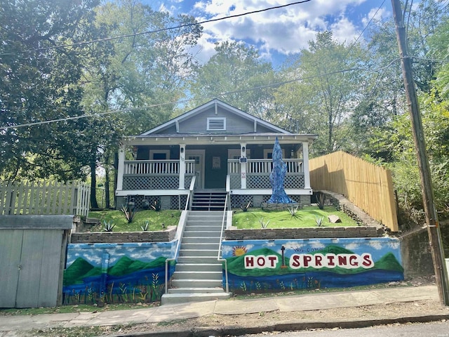 view of front facade featuring stairs, fence, and a porch