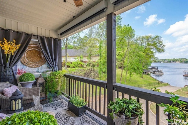 balcony featuring a ceiling fan and a water view