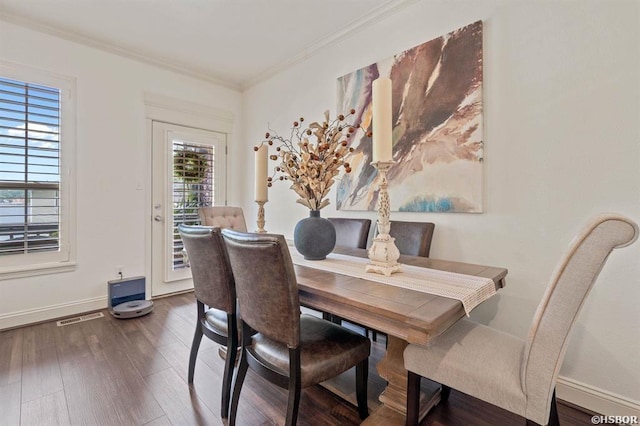 dining room featuring baseboards, ornamental molding, wood finished floors, and visible vents