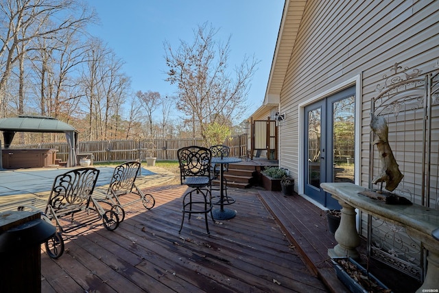 wooden terrace with fence and a hot tub